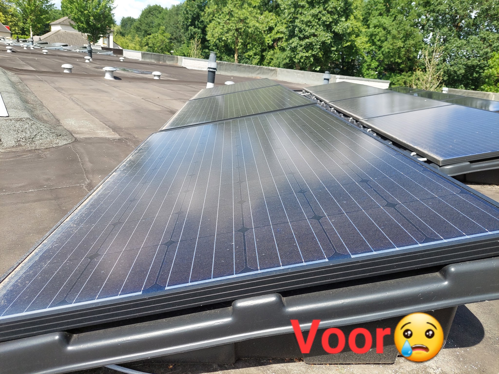 Vuile zonnepanelen op een plat dak, voor het schoonmaken